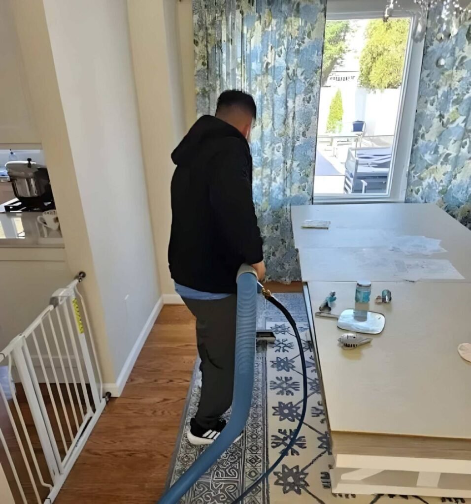 Technician cleaning a blue and white runner rug on a hardwood floor