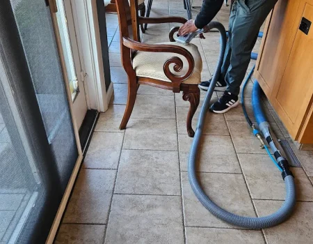 Technician cleaning the fabric seat of a wooden dining chair