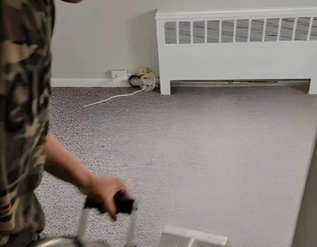 Technician cleaning gray wall-to-wall carpet in a Long Island home